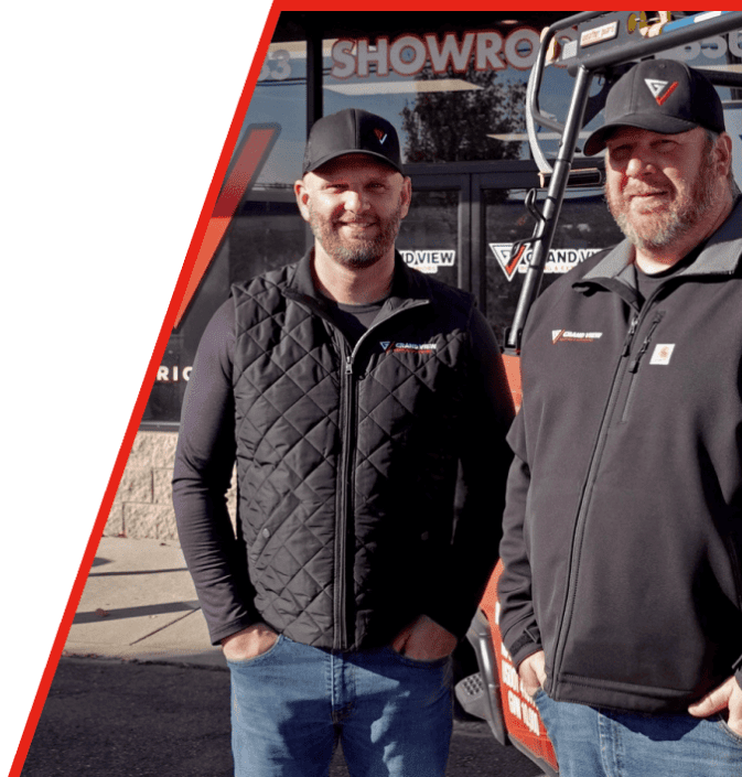 Two smiling business partners in branded clothing standing in front of showroom