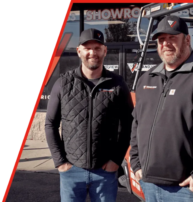 Two smiling business partners in branded clothing standing in front of showroom