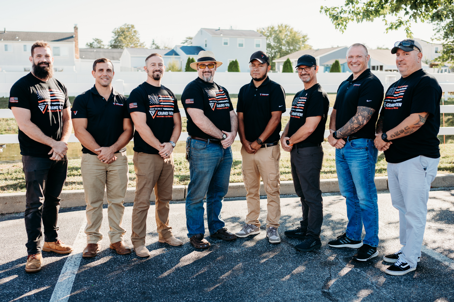 Eight men in matching black Grand Vu company shirts standing together for team photo
