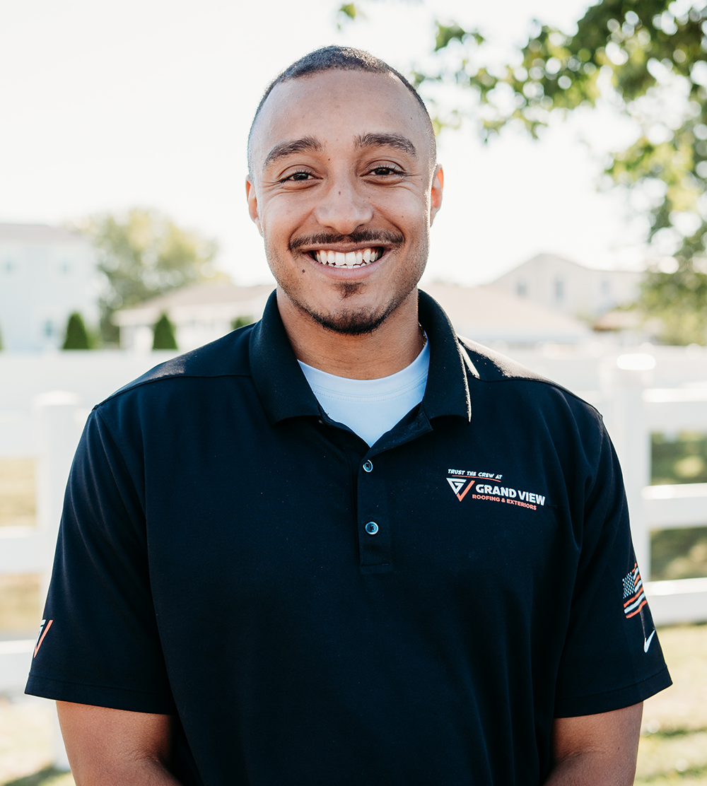 Smiling man in navy GrandView Roofing polo shirt outdoors professional headshot