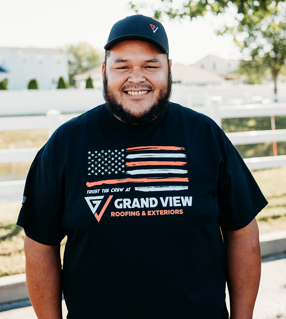 Smiling man in Grand View Roofing & Exteriors shirt with American flag design