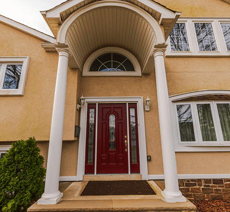 Elegant home entrance with a red door and white columns