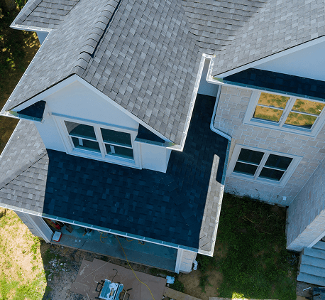Aerial view of a house with newly installed asphalt shingle roofing.