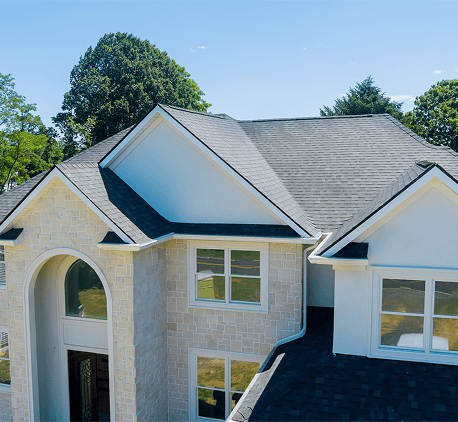 Aerial view of modern slate roofed house amidst trees